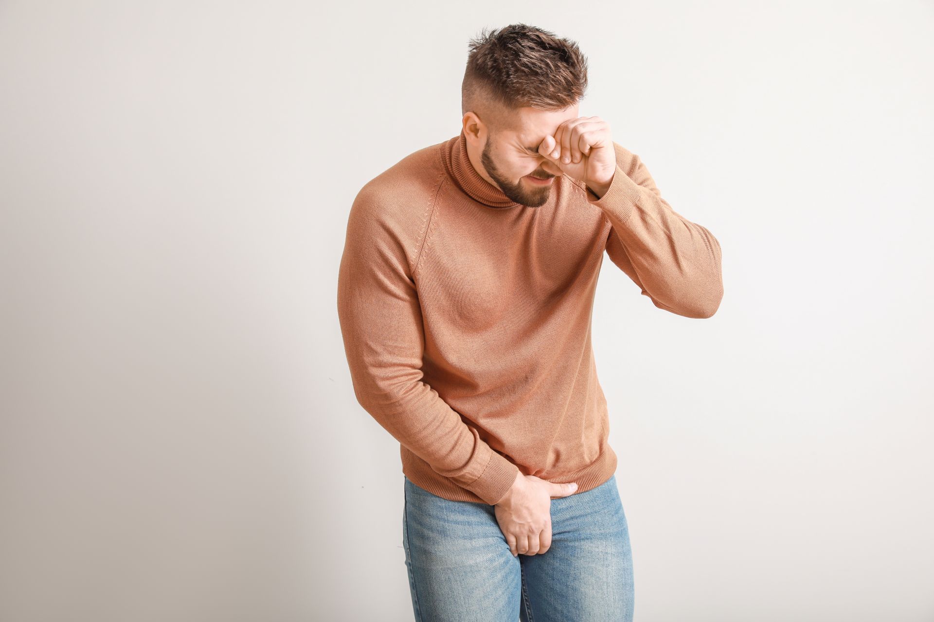 Young man with urologic disease on light background
