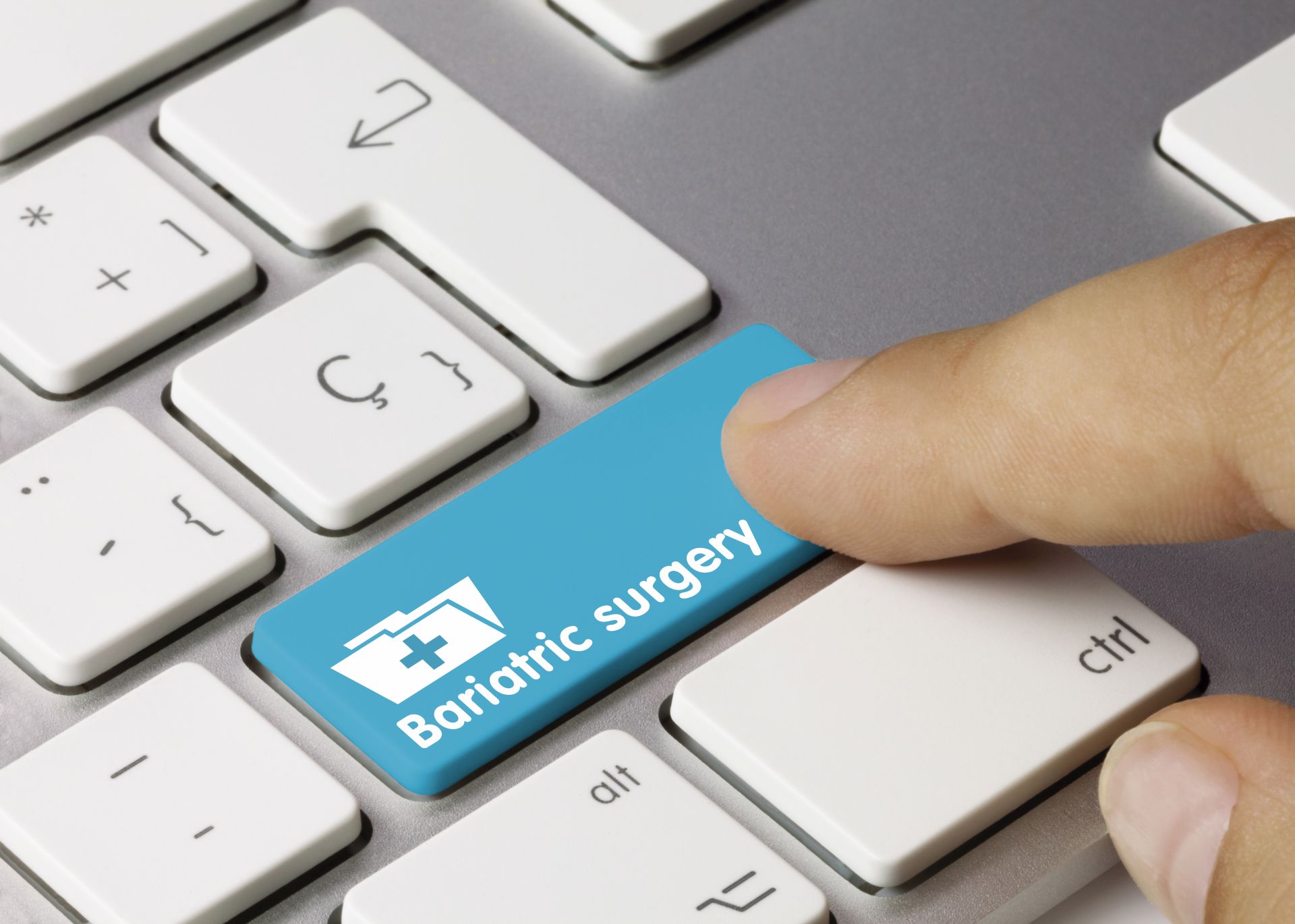 Bariatric surgery Written on Blue Key of Metallic Keyboard. Finger pressing key.